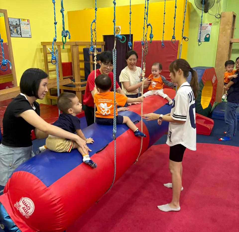 Child building social confidence through group play at My Gym Singapore